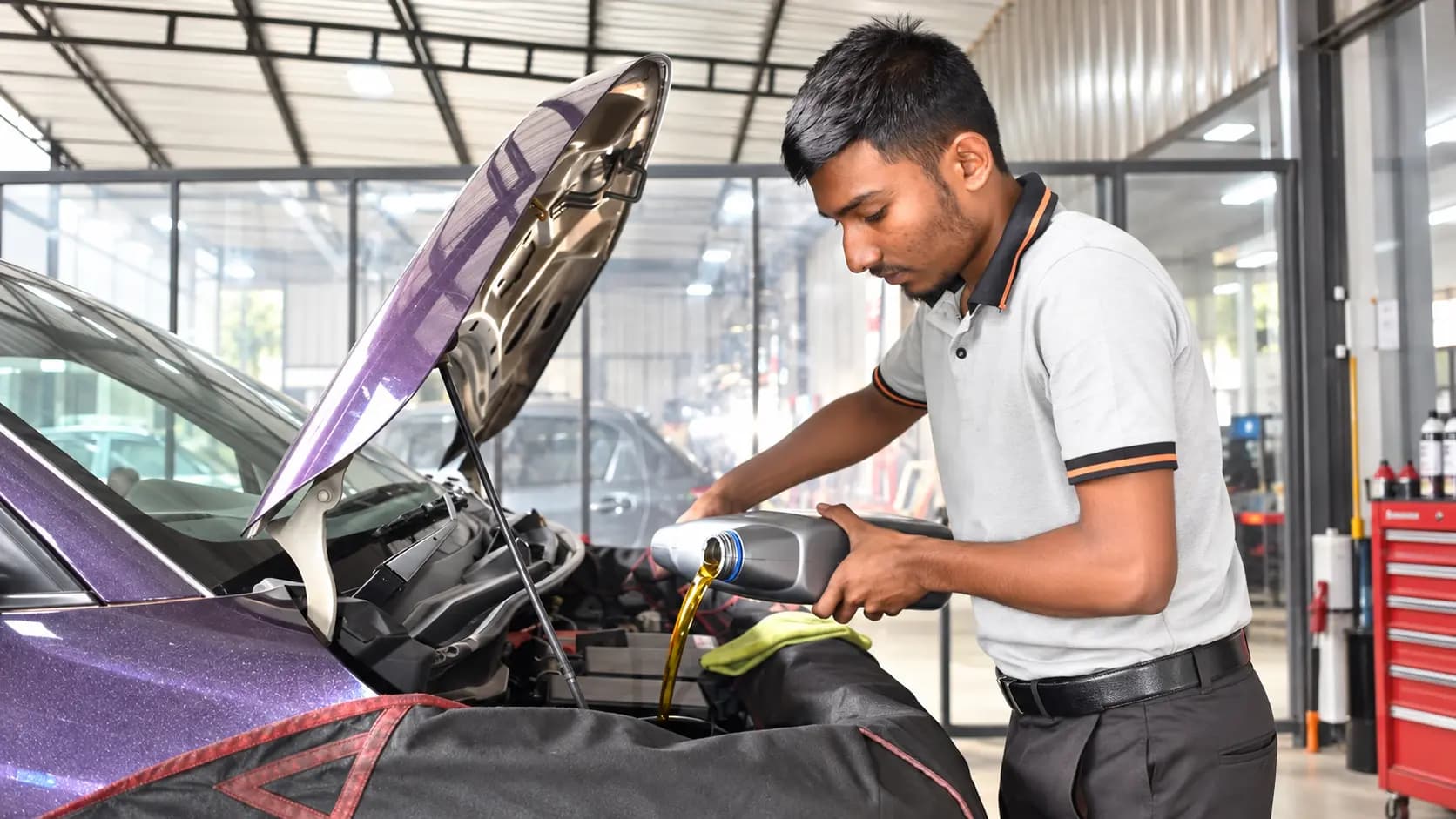EasyCare technician adding engine oil during a lubrication service